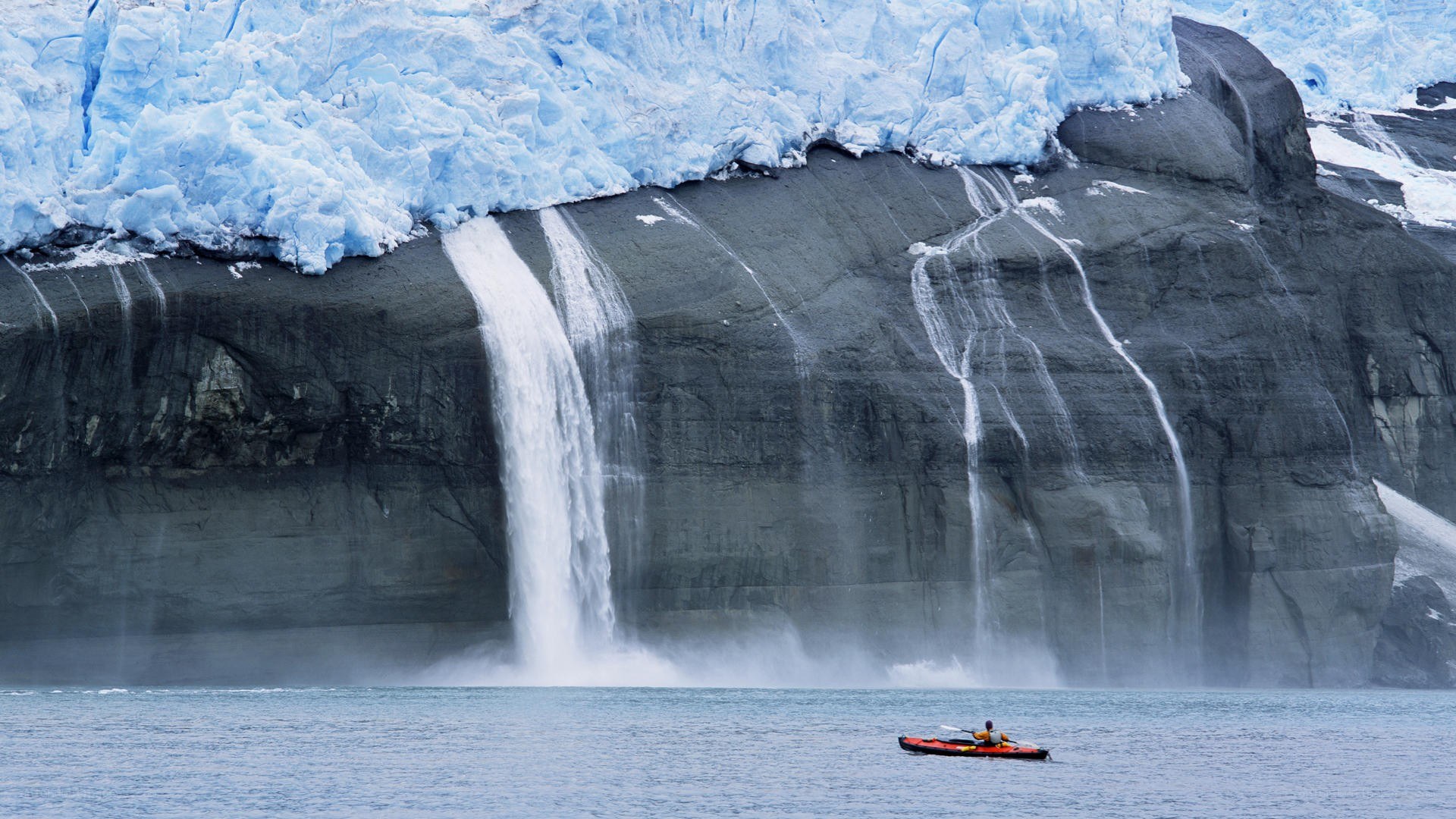kayaker near glacier waterfall