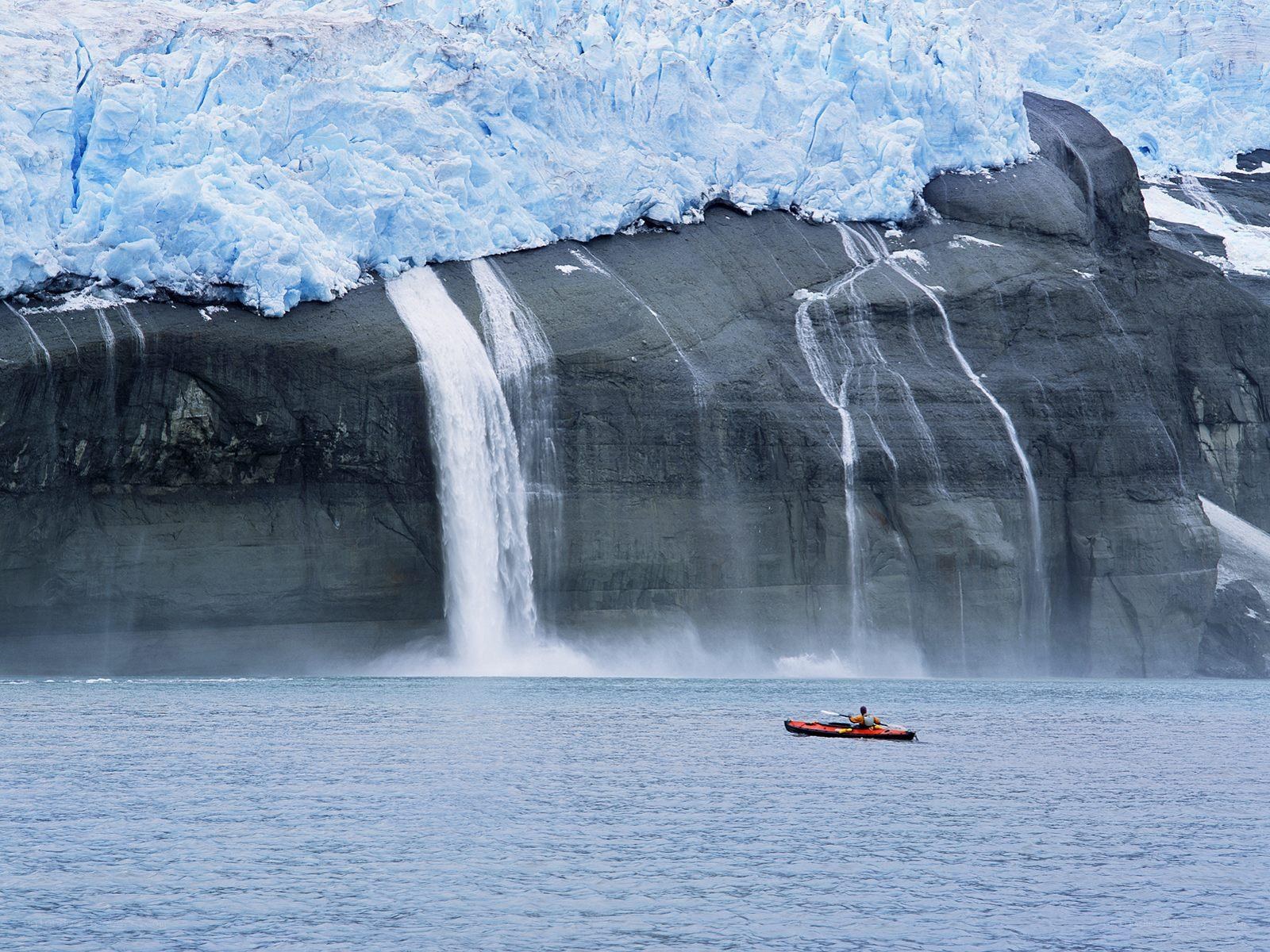 kayaker near glacier waterfall