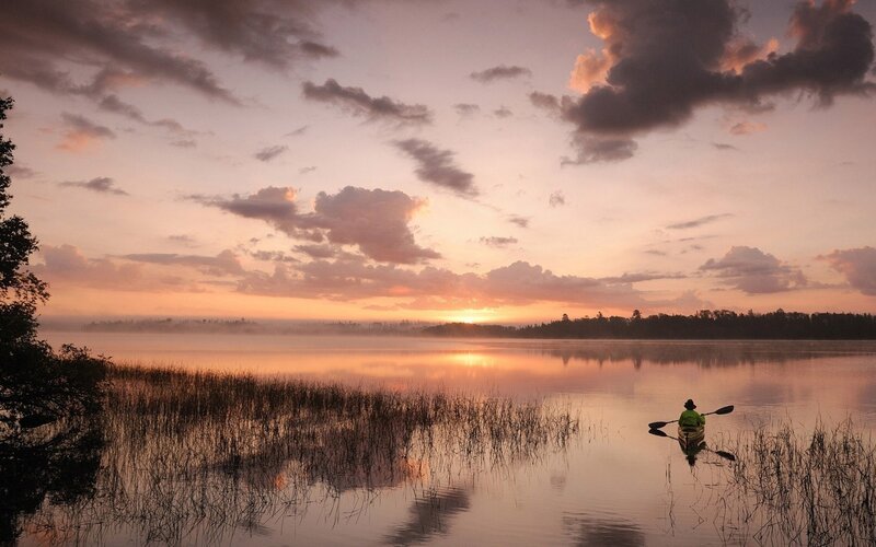 kayaker on a misty lake at sunrise