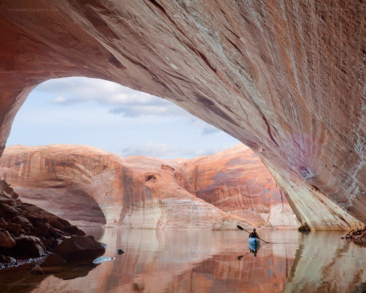 kayaker under a rock arch