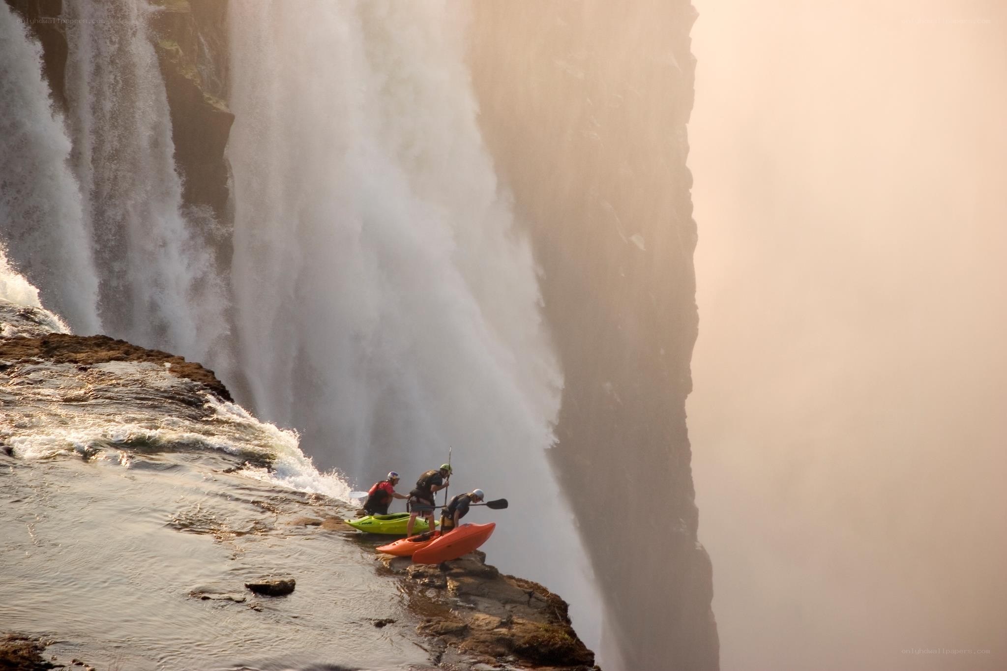 Kayakers at a waterfall edge