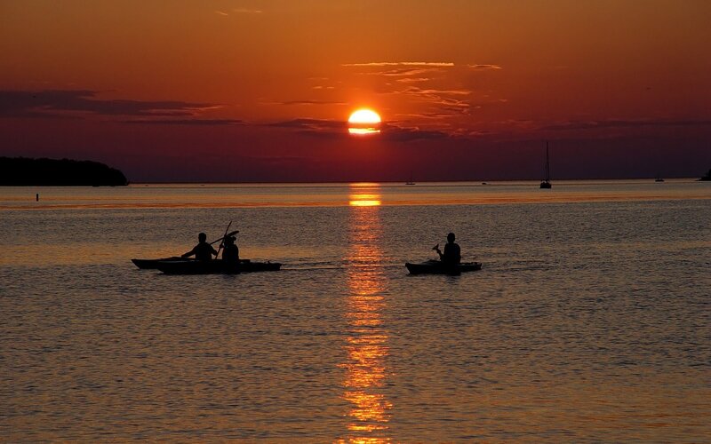 Kayakers at sunset on calm water