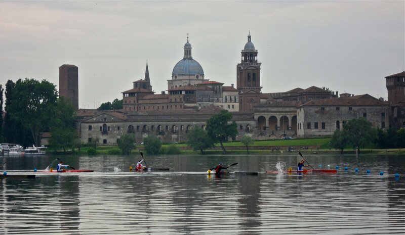Kayakers on a river with historic buildings