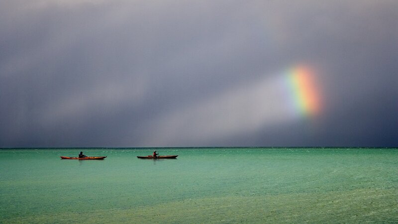 Kayakers under a rainbow