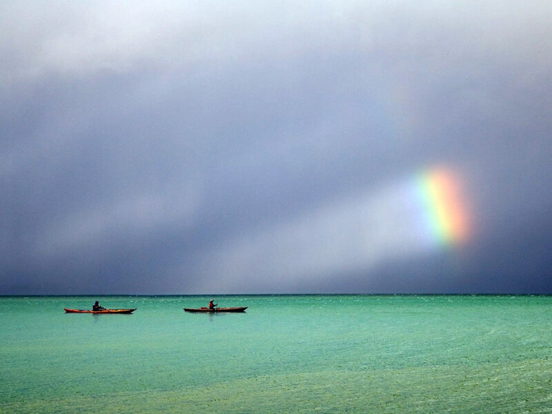 Kayakers under a rainbow