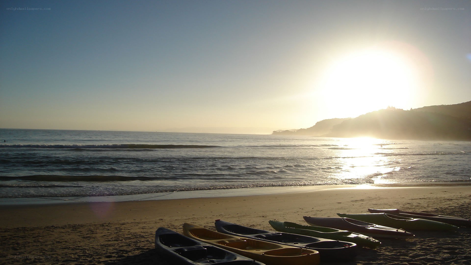 Kayaks on beach at sunset