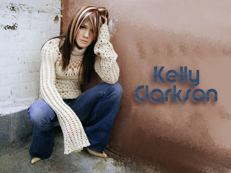Kelly Clarkson sitting against a wall