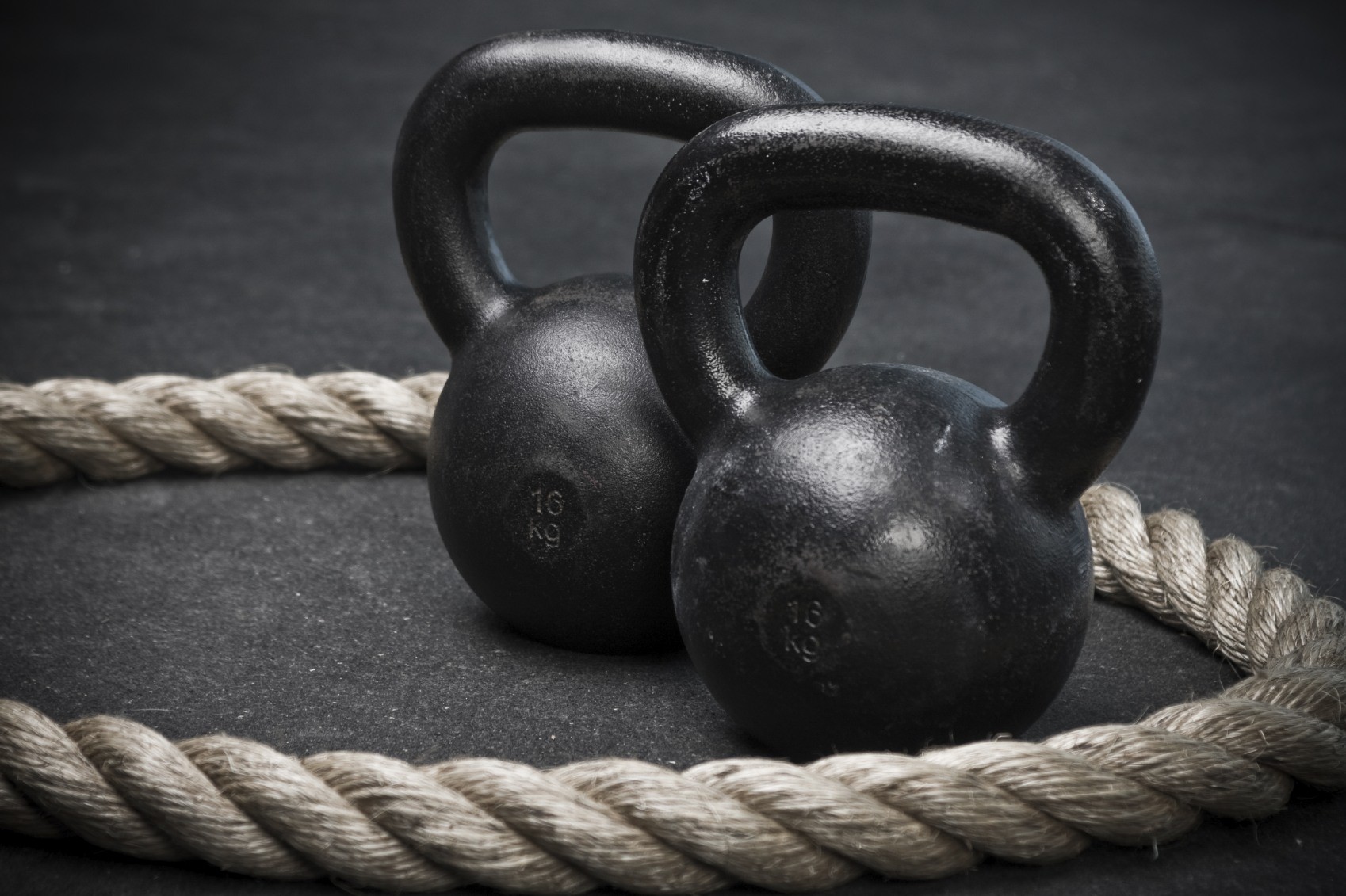 kettlebells and rope on dark surface