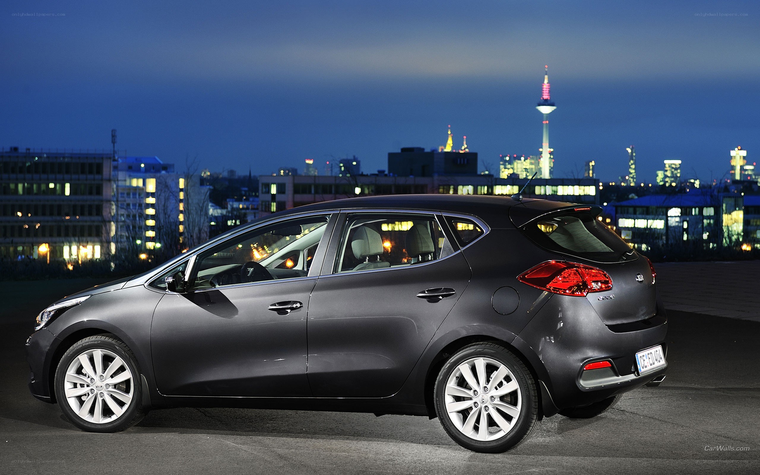 Kia Ceed at night with city skyline