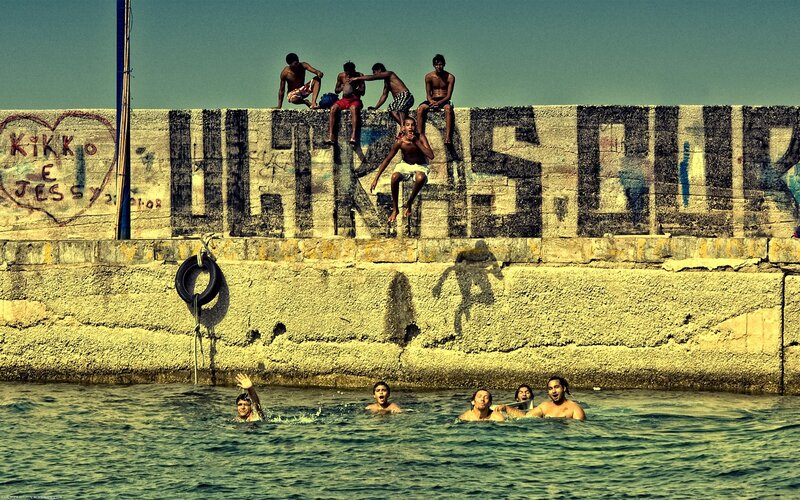 Kids swimming at a pier