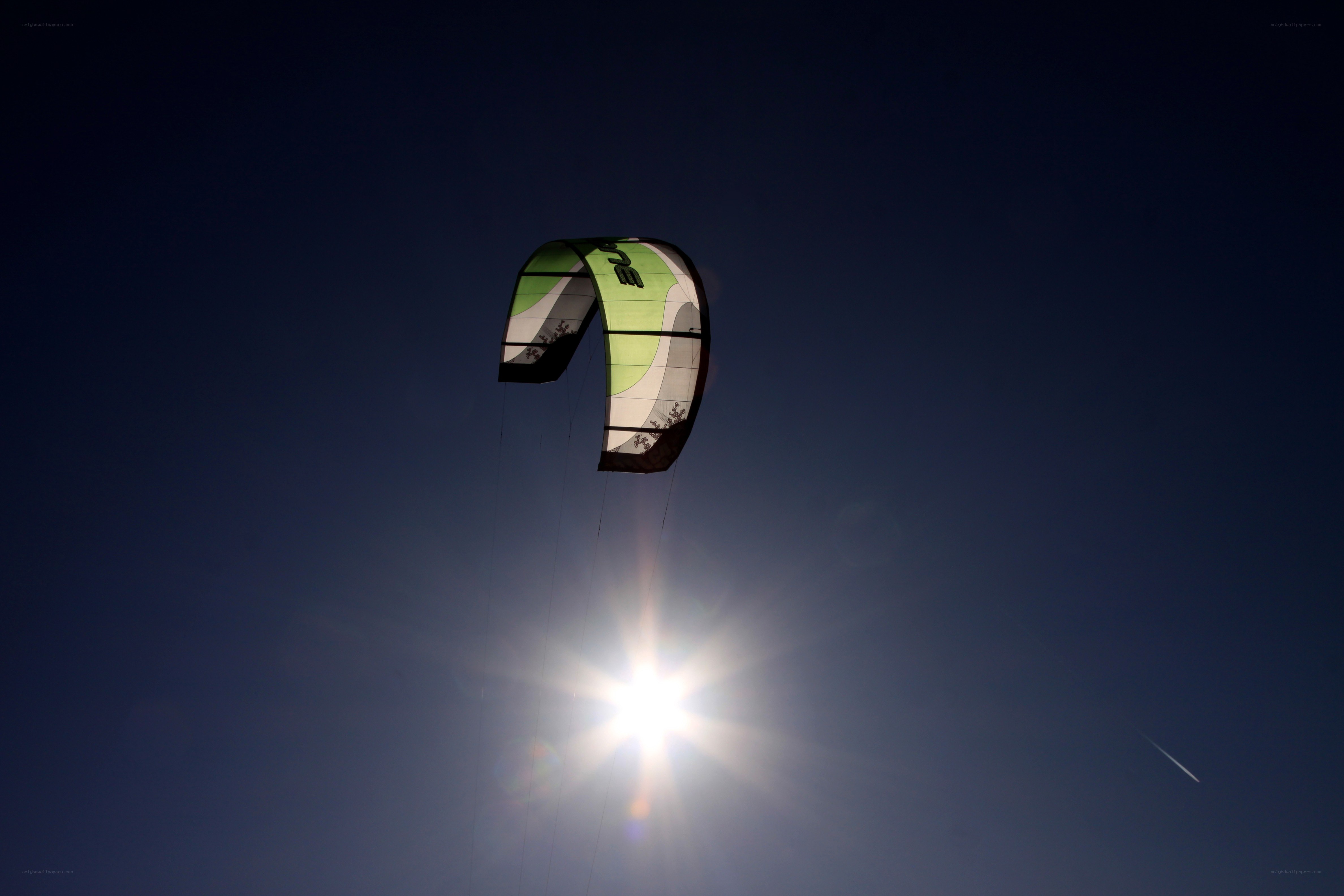 kite flying against the sun