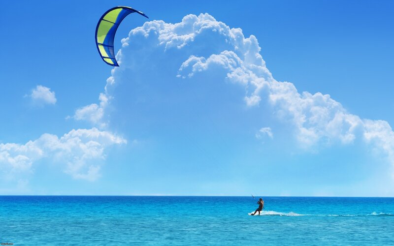 kiteboarding over blue ocean