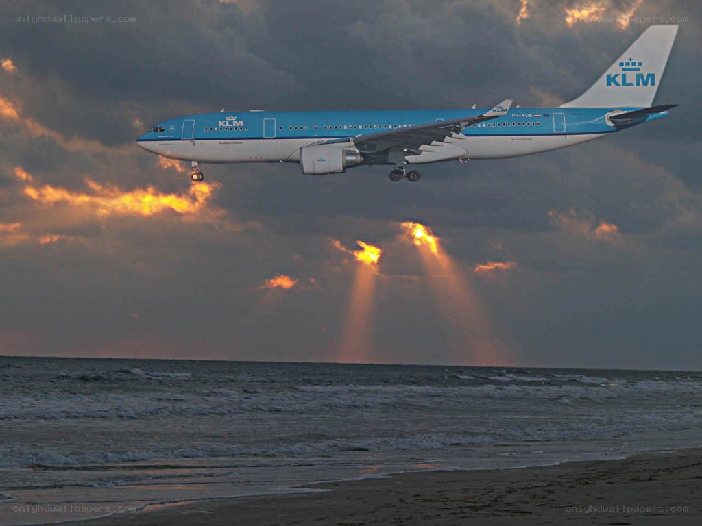 KLM airplane landing at sunset