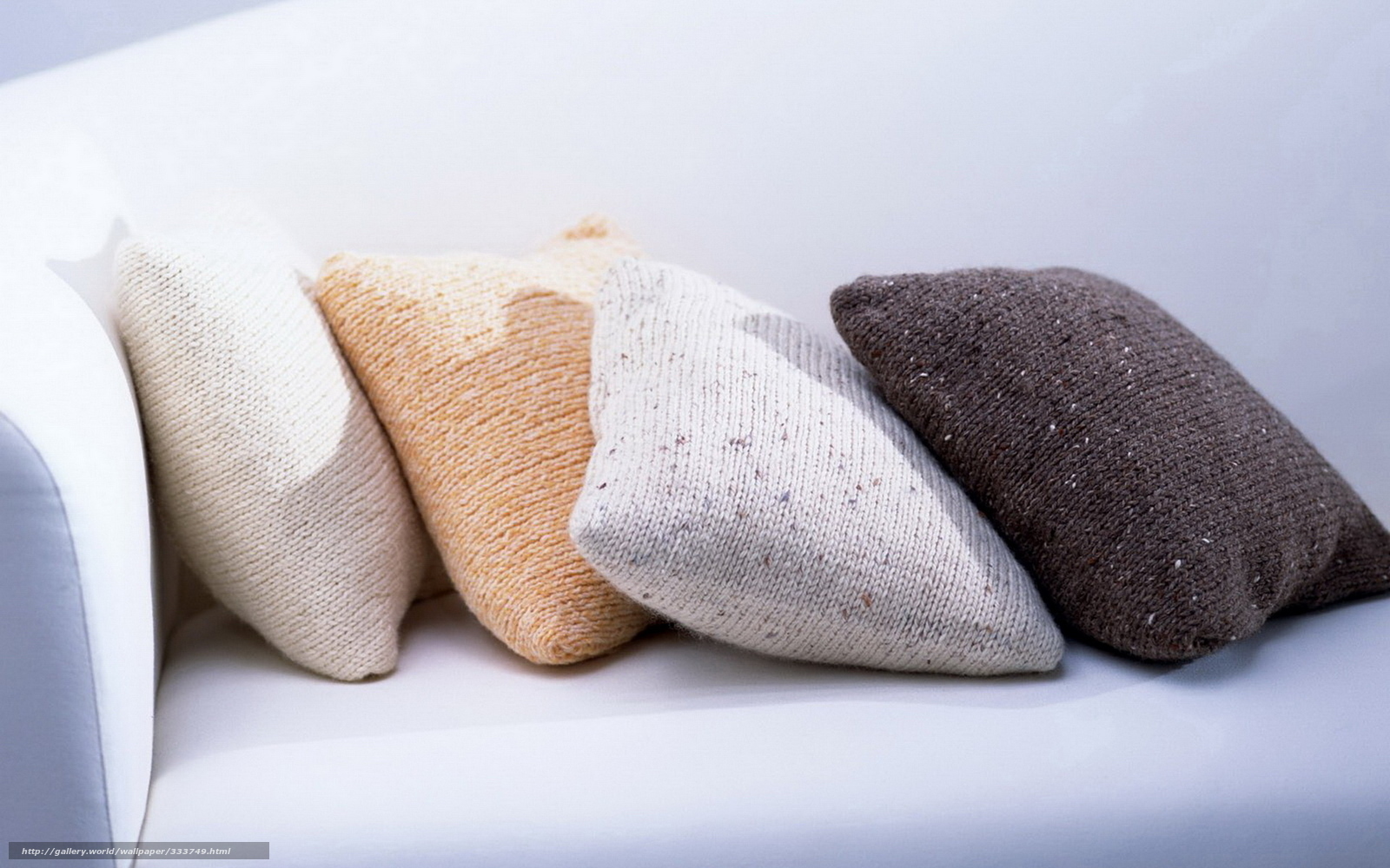 Knitted pillows on a white sofa