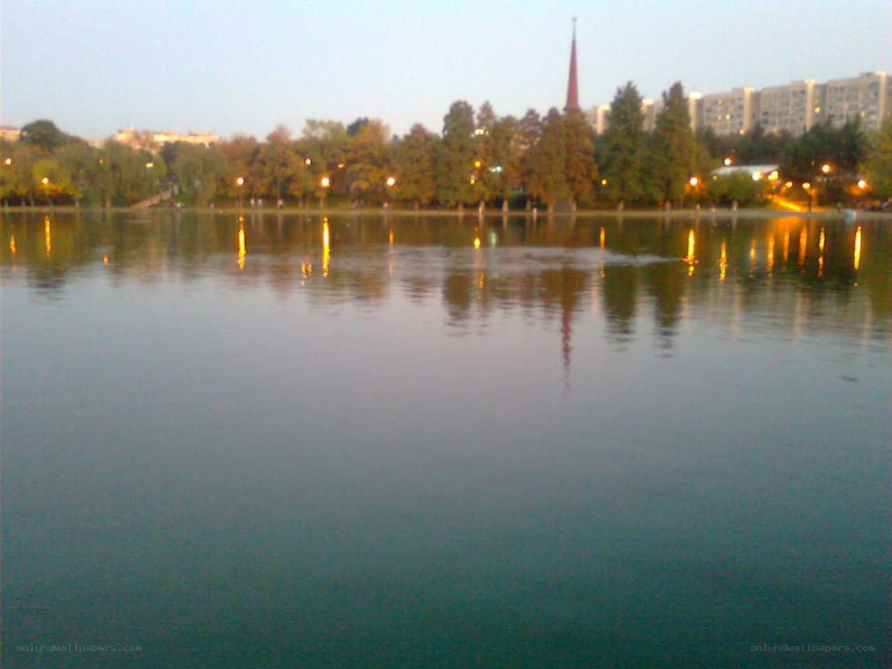 Lake at dusk with city lights