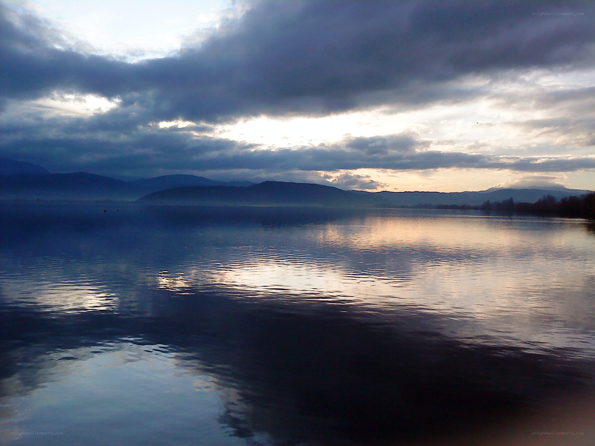 Lake at dusk with cloudy sky