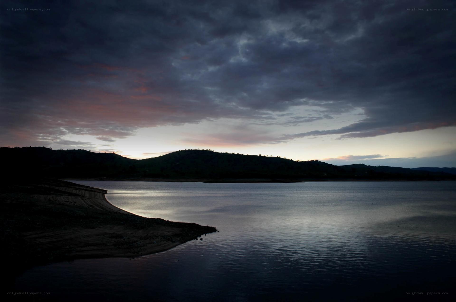 Lake at dusk with cloudy sky