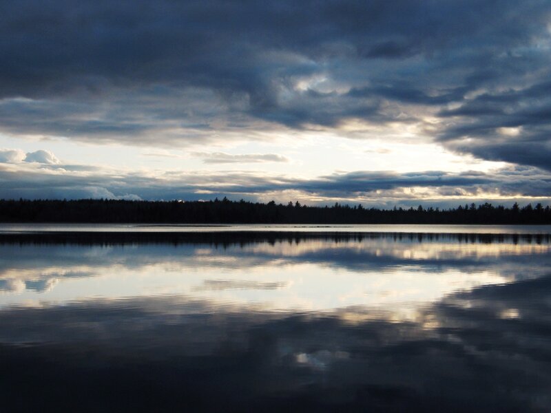 Lake at dusk with cloudy sky