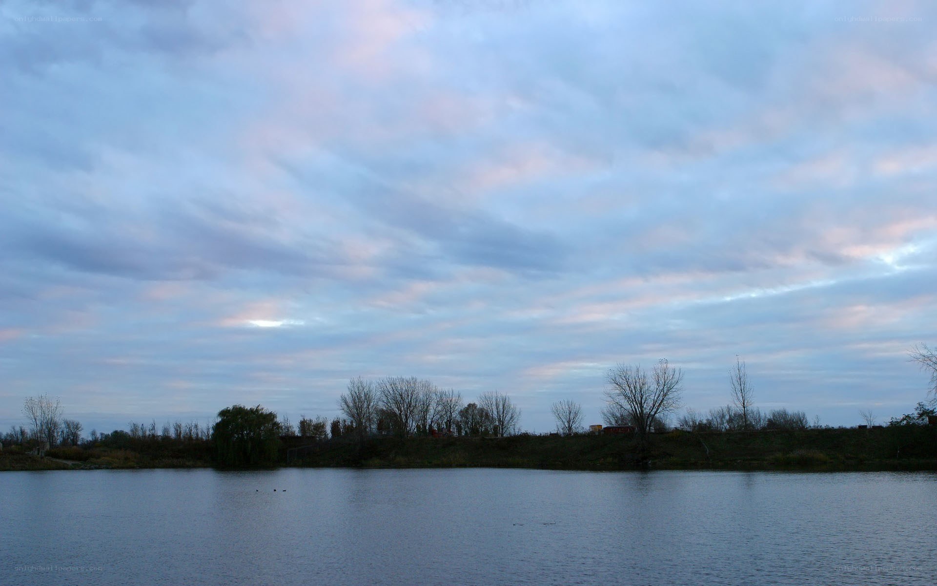 Lake at dusk with cloudy sky