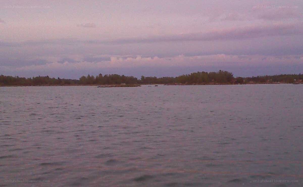 Lake at dusk with distant trees