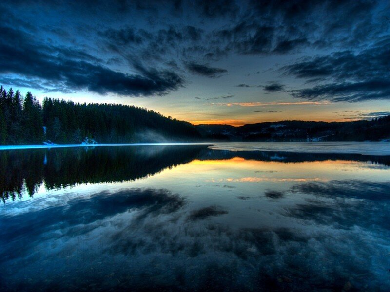 Lake at dusk with forest reflection