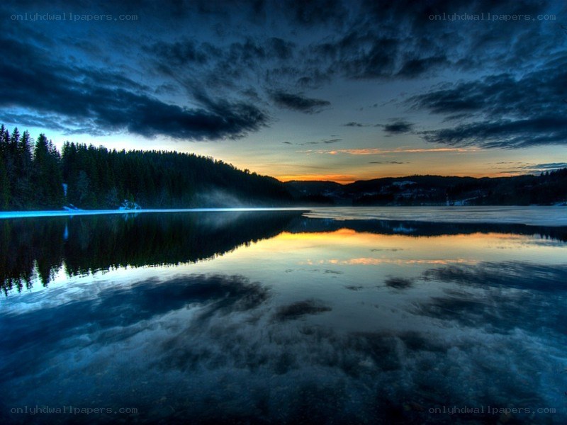 Lake at dusk with forest reflection