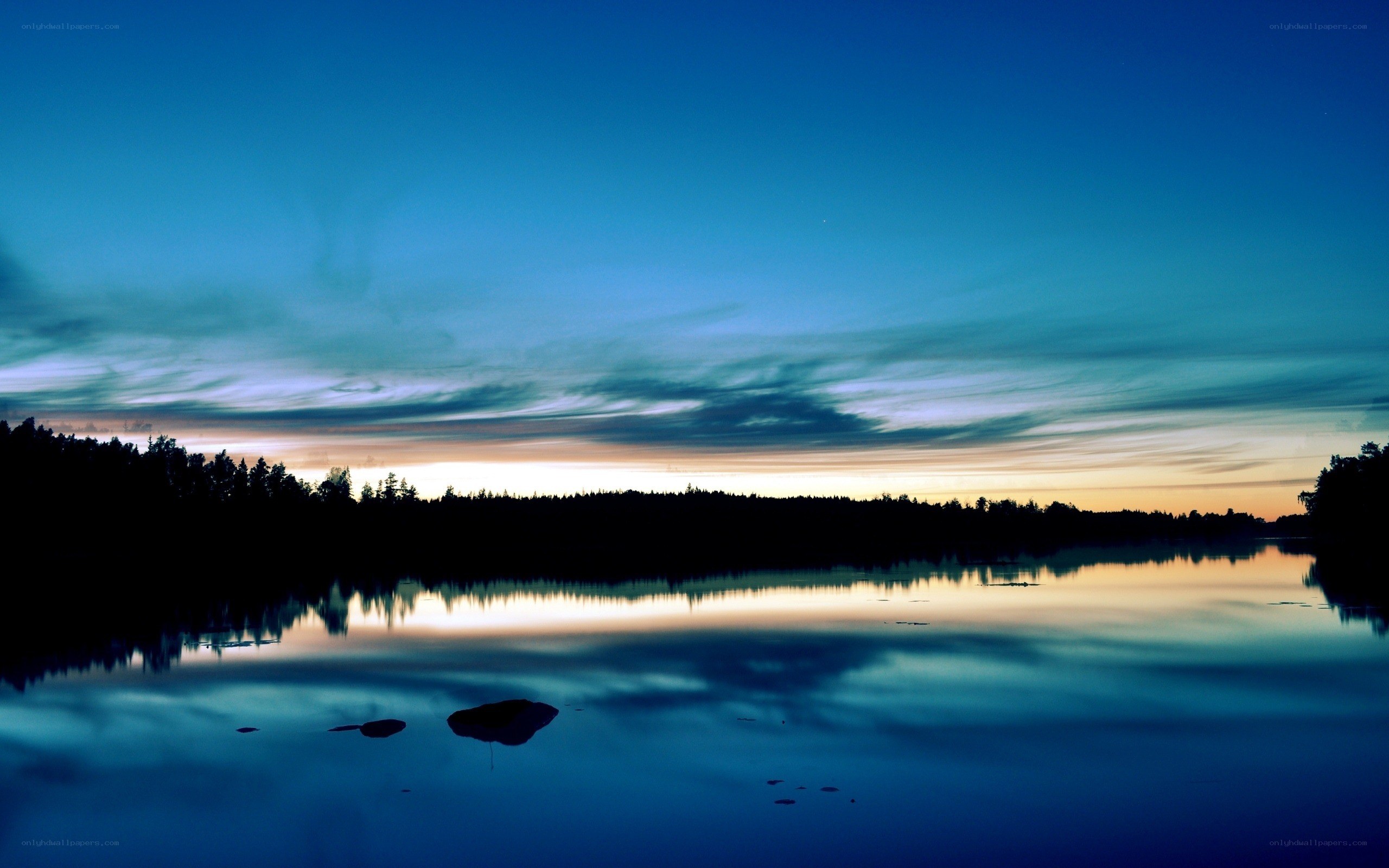 Lake at twilight with forest silhouette