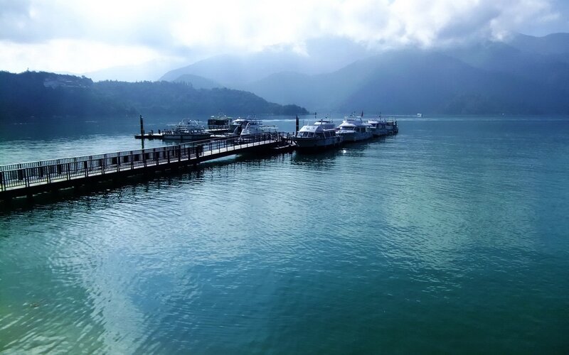 Lake dock with boats and mountains