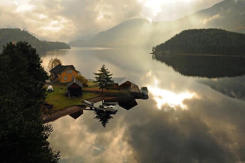 Lake house at sunrise with mountains