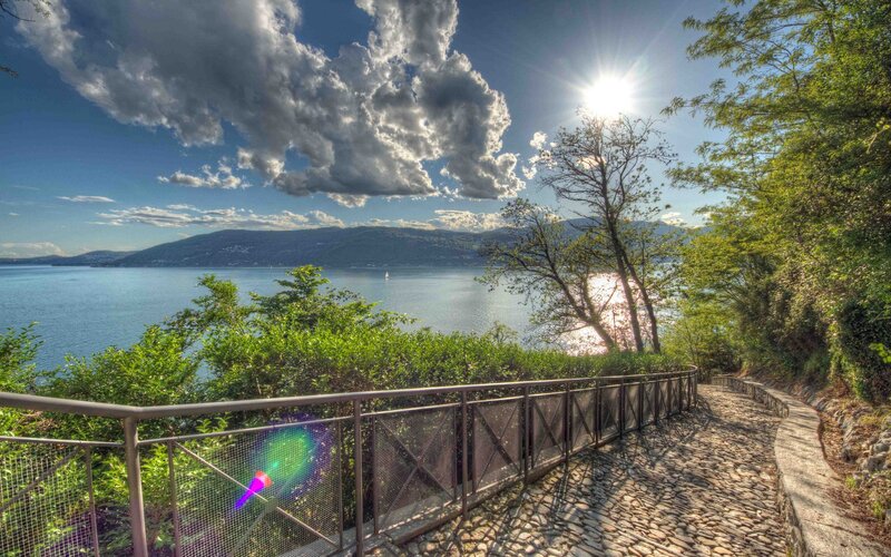 Lake path with sun and clouds