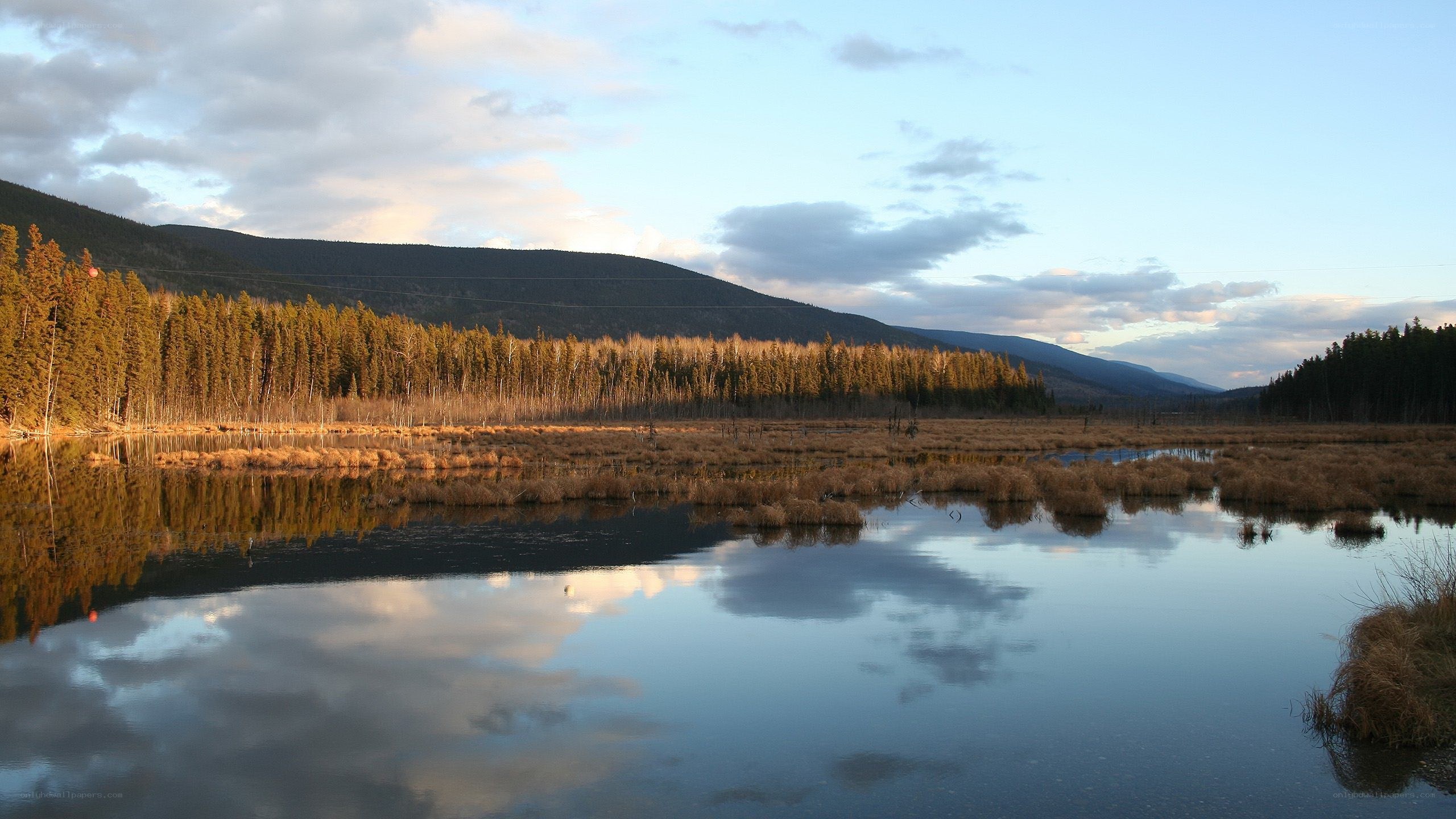 Lake reflecting mountains at sunset