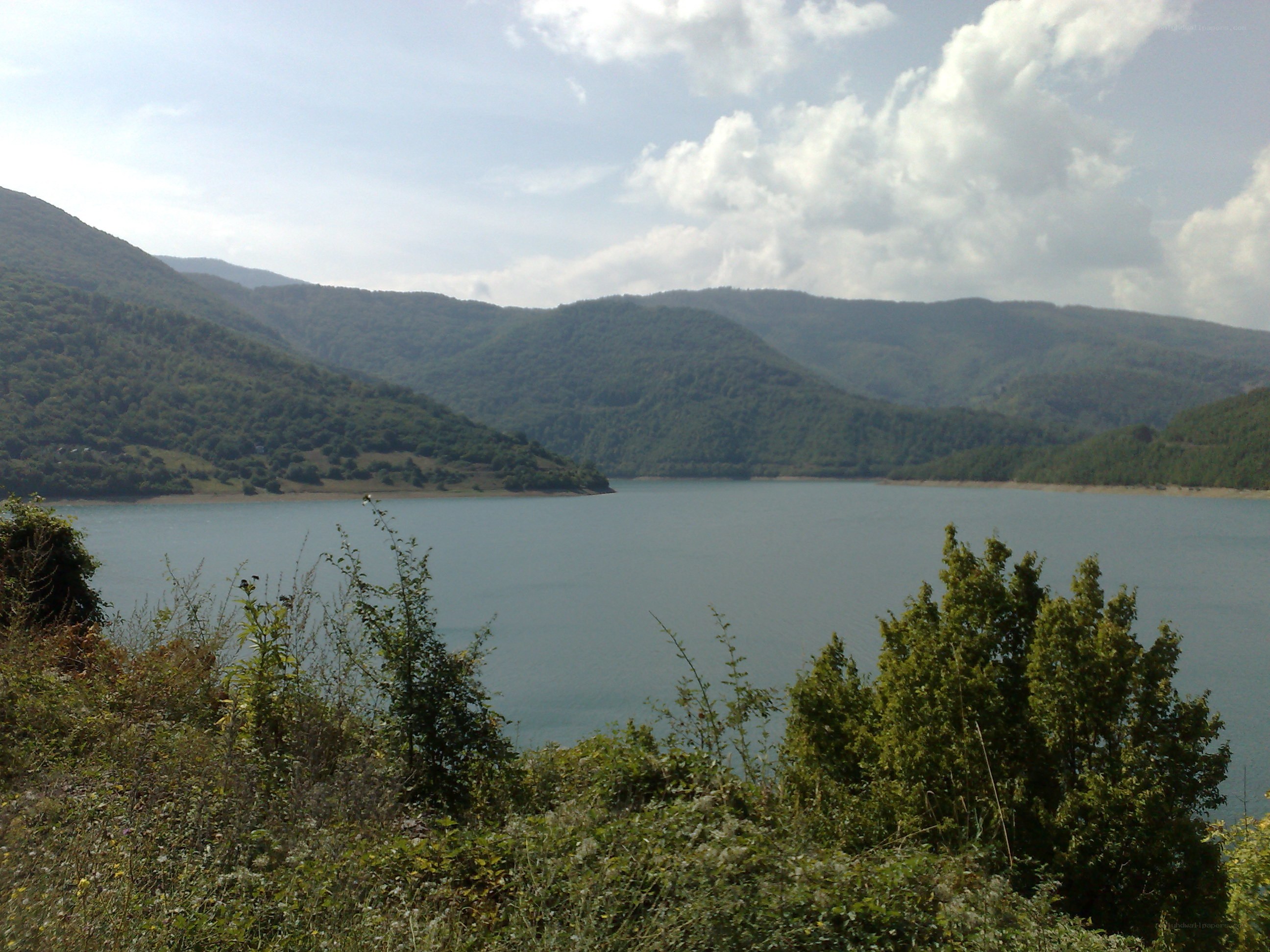 Lake surrounded by green hills