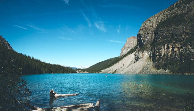 Lake Surrounded by Mountains — Blue, Serene, Afternoon, Photograph, Trees, Driftwood