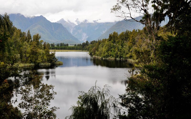 Lake Surrounded by Mountains — Green, Serene, Afternoon, Photograph, Trees, Forest