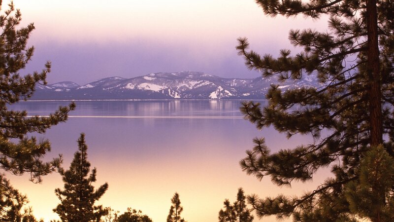 Lake Tahoe at dusk with snow-capped mountains
