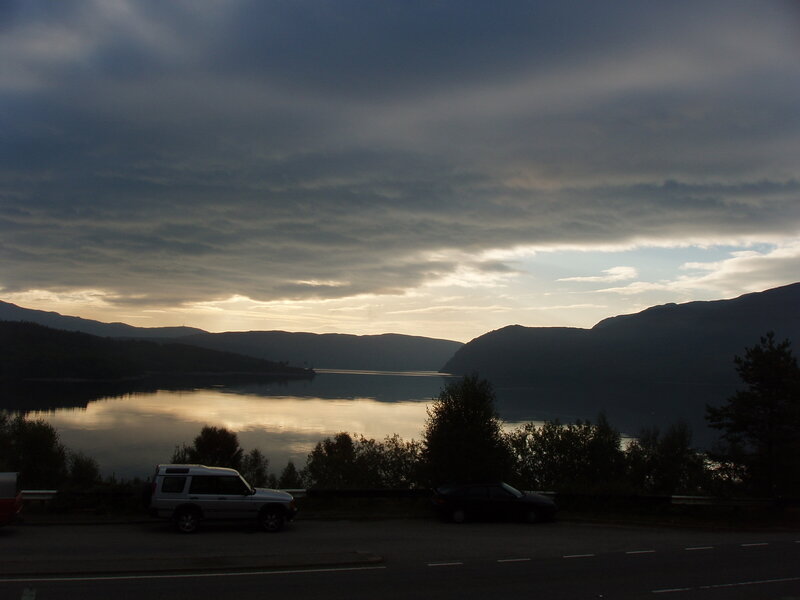 Lake view at dusk with cars