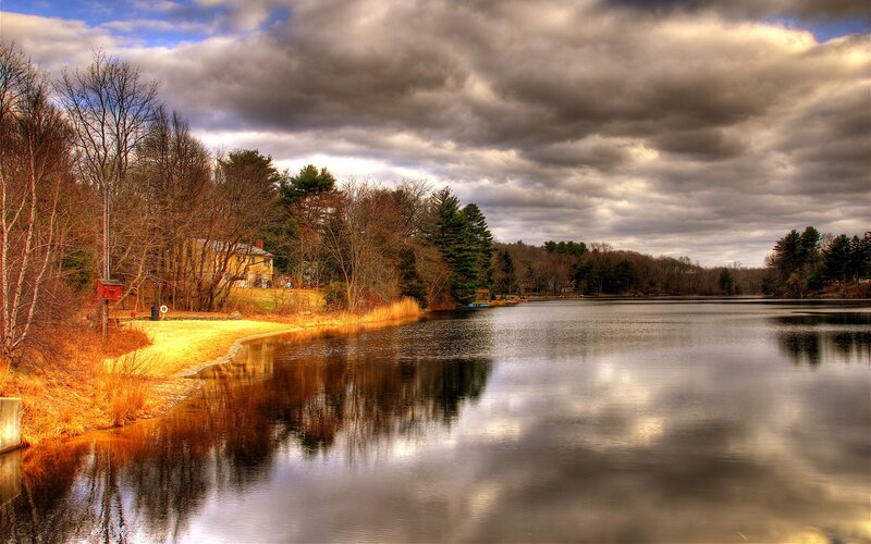 Lake with autumn trees and cloudy sky