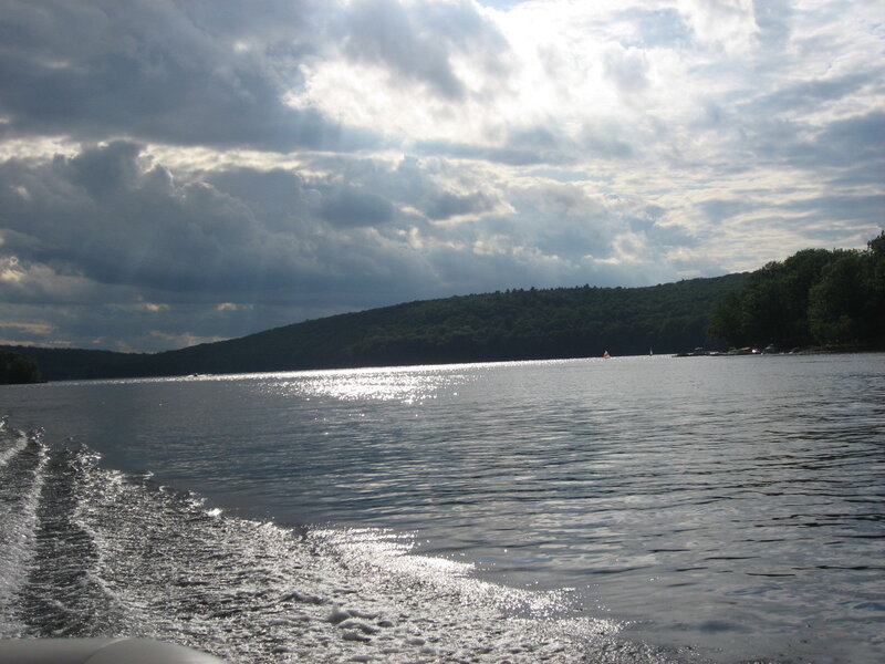 Lake with boat wake and cloudy sky