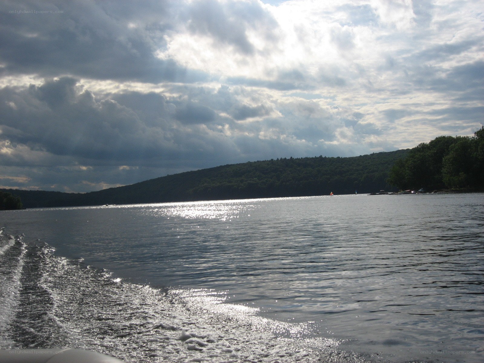 Lake with boat wake and cloudy sky