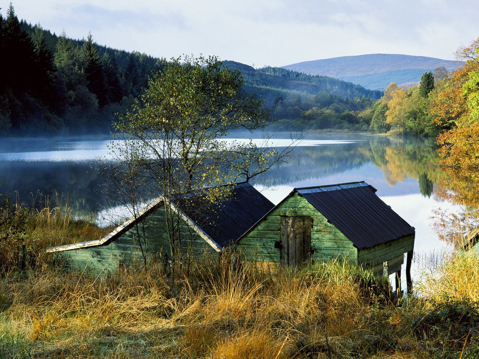 Lake with boathouses and mist