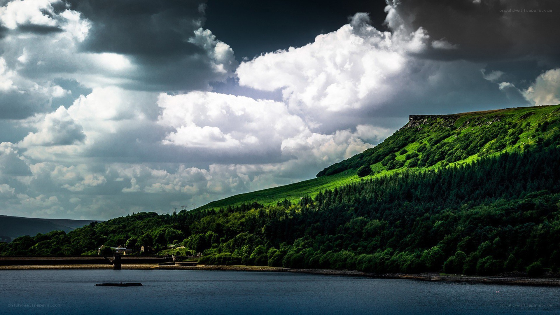 Lake with green hills and cloudy sky