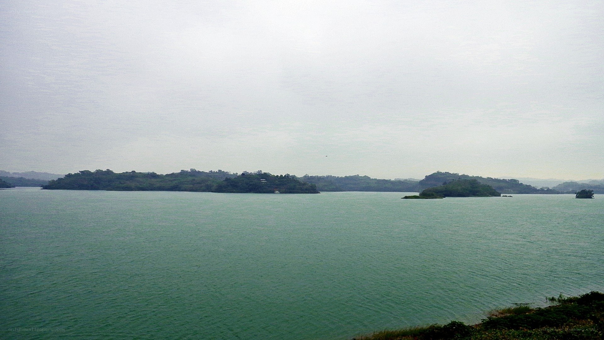 Lake with islands under overcast sky