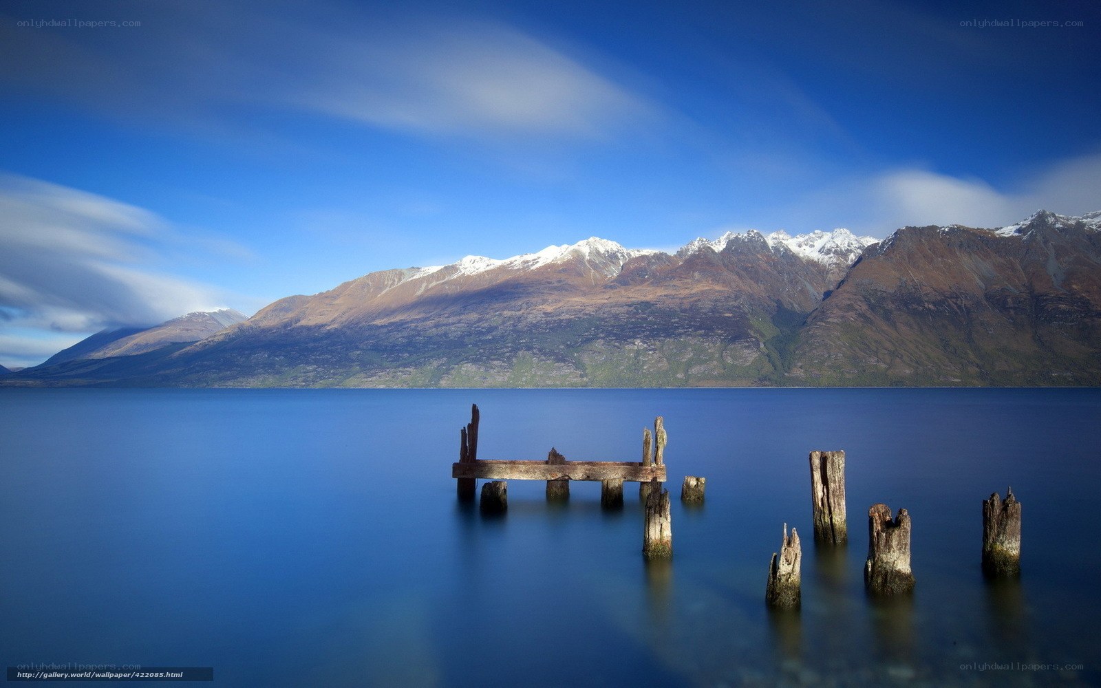 Lake with old pier and mountains