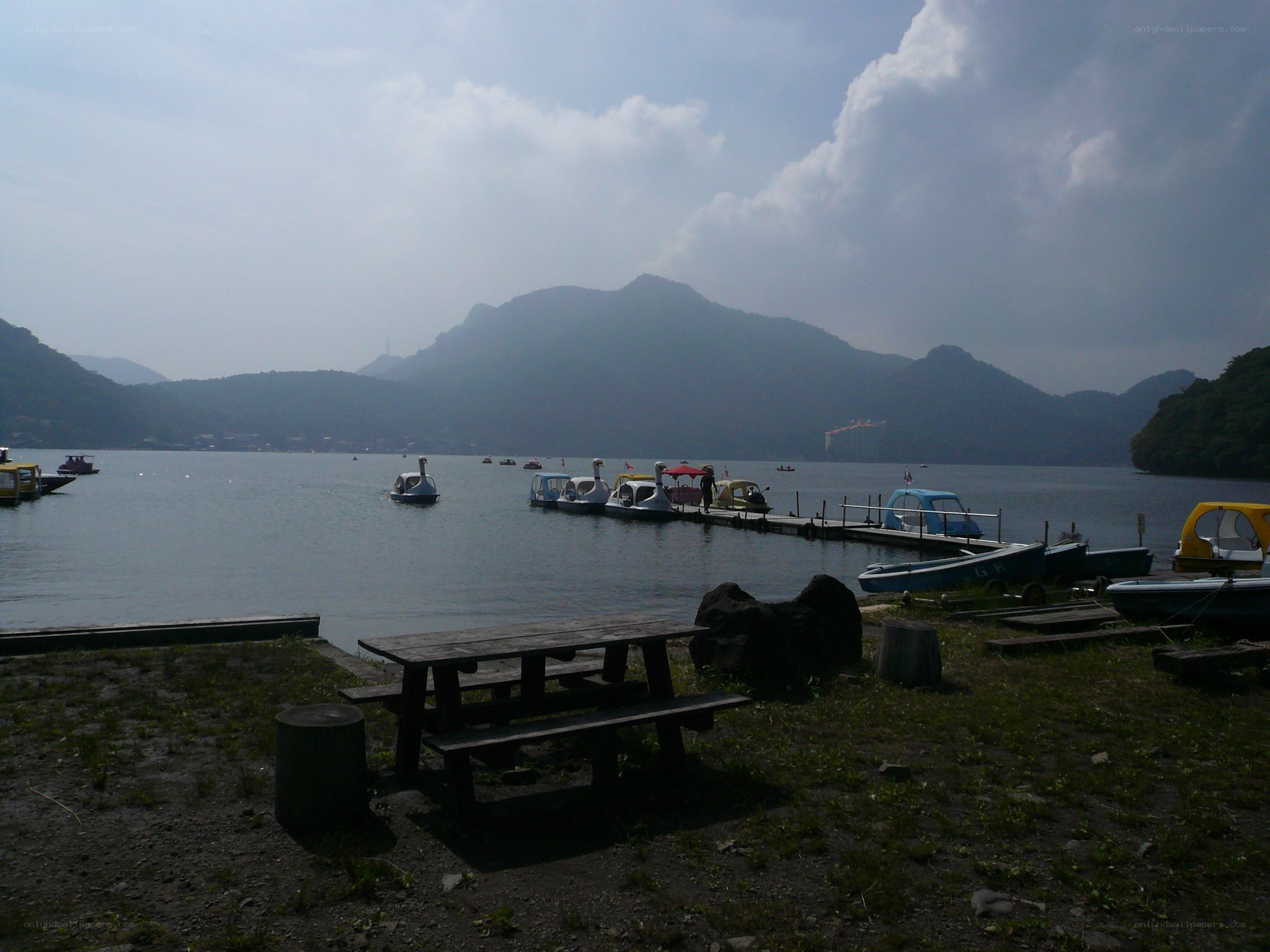 Lake with paddle boats and mountains