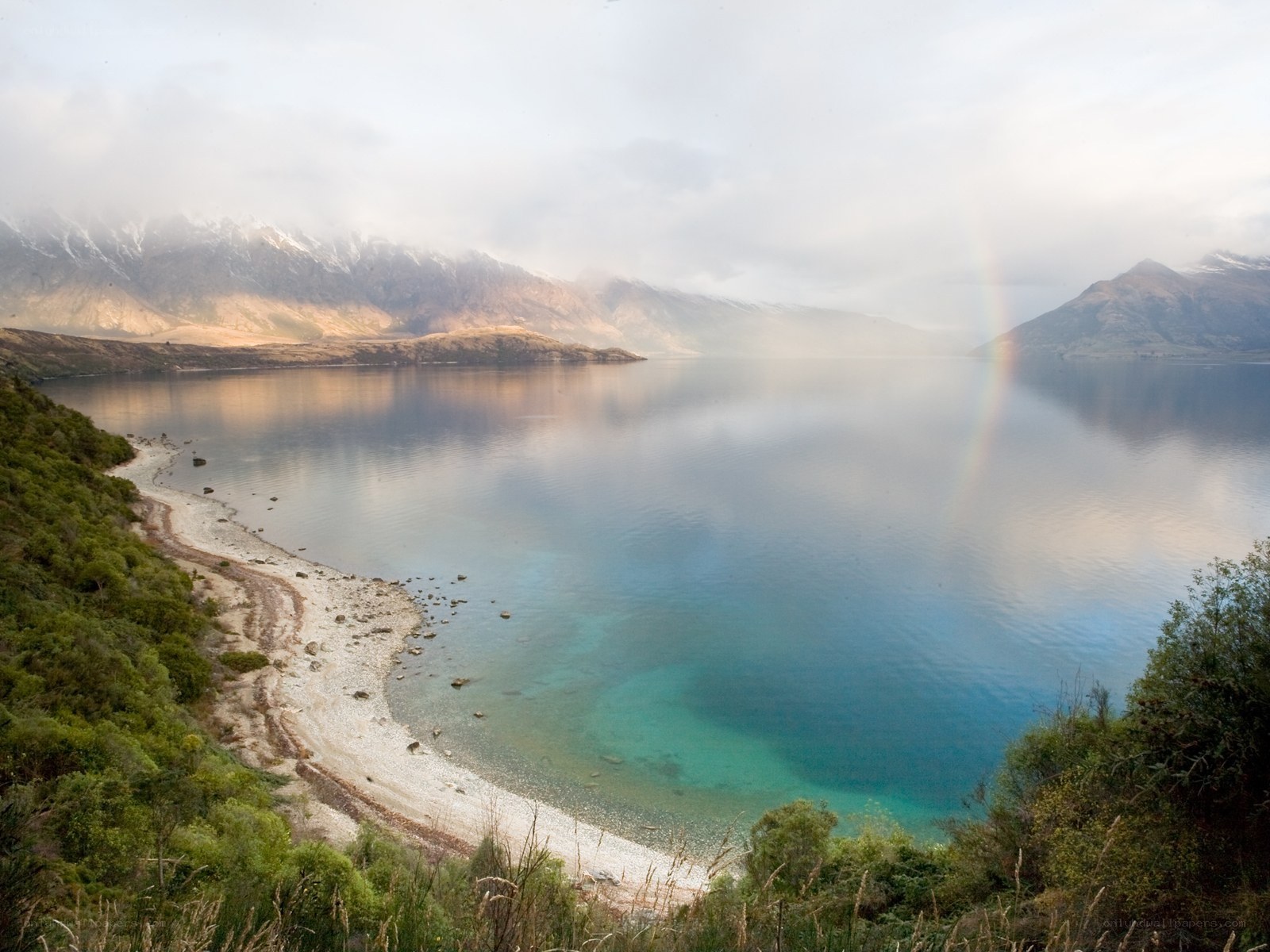 Lake with rainbow and mountains
