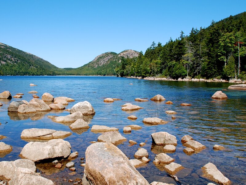 Lake with rocks and forested hills