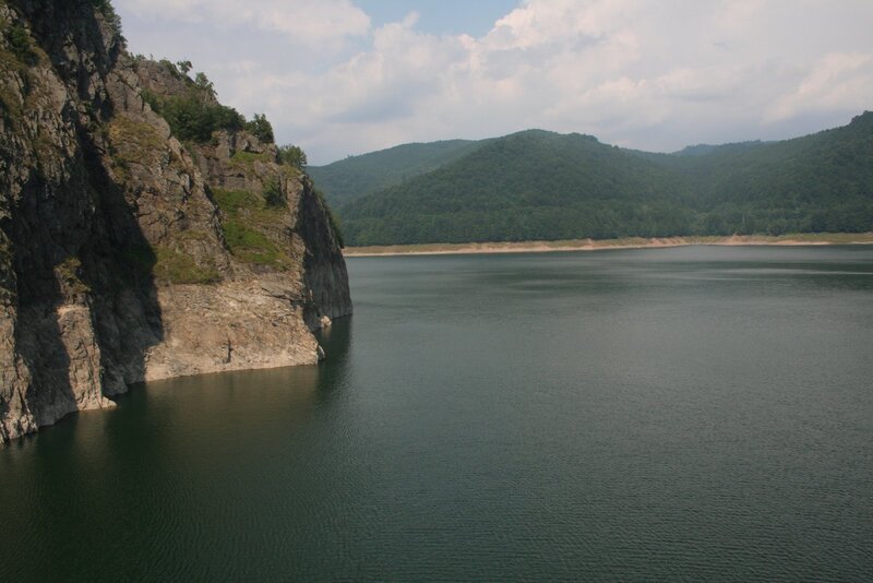 Lake with rocky cliff and forested hills
