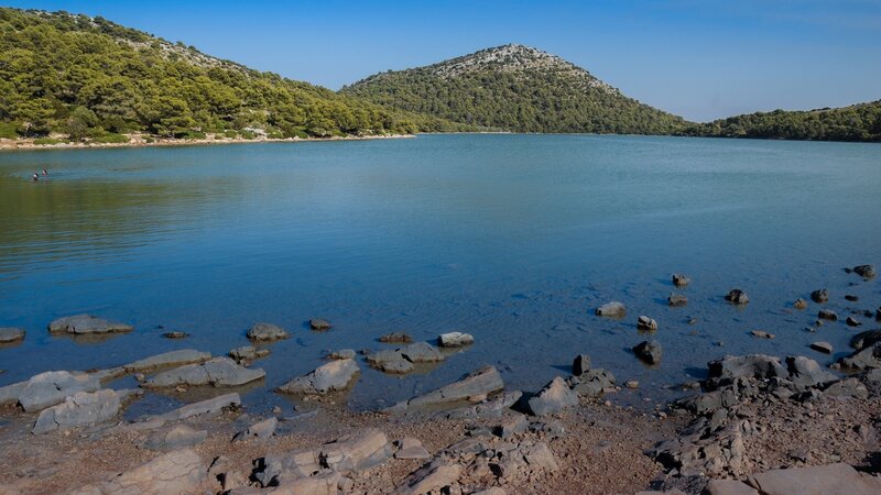 Lake with rocky shore and green hills