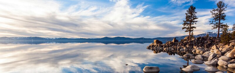 Lake with Rocky Shore — Blue, Serene, Morning, Photograph, Trees, Mountains, Clouds