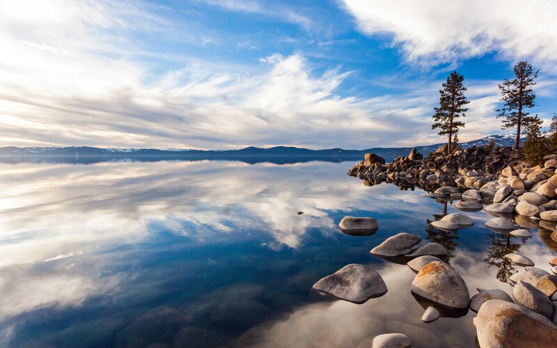Lake with Rocky Shore — Blue, Serene, Morning, Photograph, Trees, Mountains